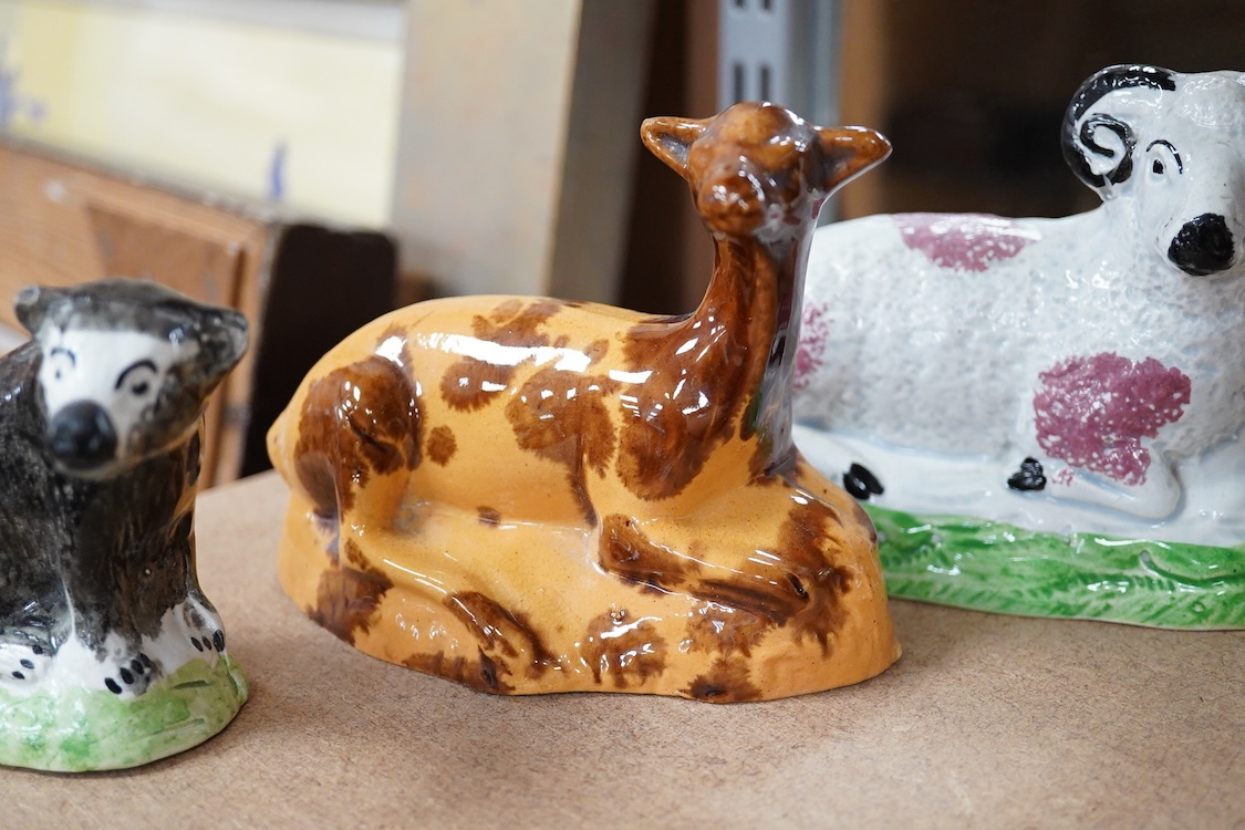 A Staffordshire Pearlware figure of a recumbent ewe, a Staffordshire glazed terracotta figure of a recumbent deer and a Staffordshire pearlware model of a badger?, largest 14cm wide